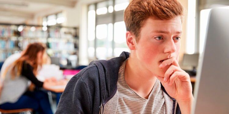 Estudiantes utilizando dispositivos tecnológicos para aprendizaje con inteligencia artificial