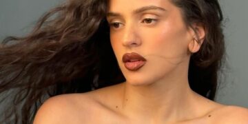 Rosalía ofreciendo concierto en escenario iluminado