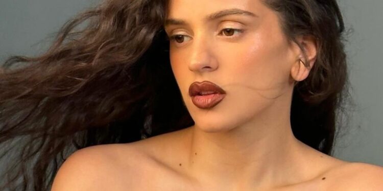 Rosalía ofreciendo concierto en escenario iluminado