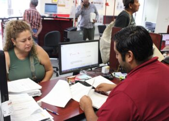 personas en oficina de ITAVU realizando trámites de escrituración