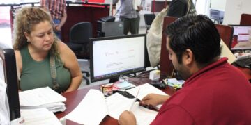 personas en oficina de ITAVU realizando trámites de escrituración