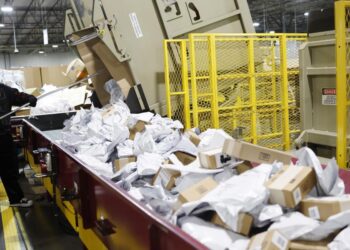 Empleado clasificando paquetes para temporada festiva en Estados Unidos