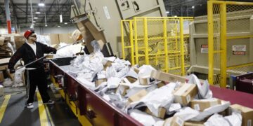 Empleado clasificando paquetes para temporada festiva en Estados Unidos